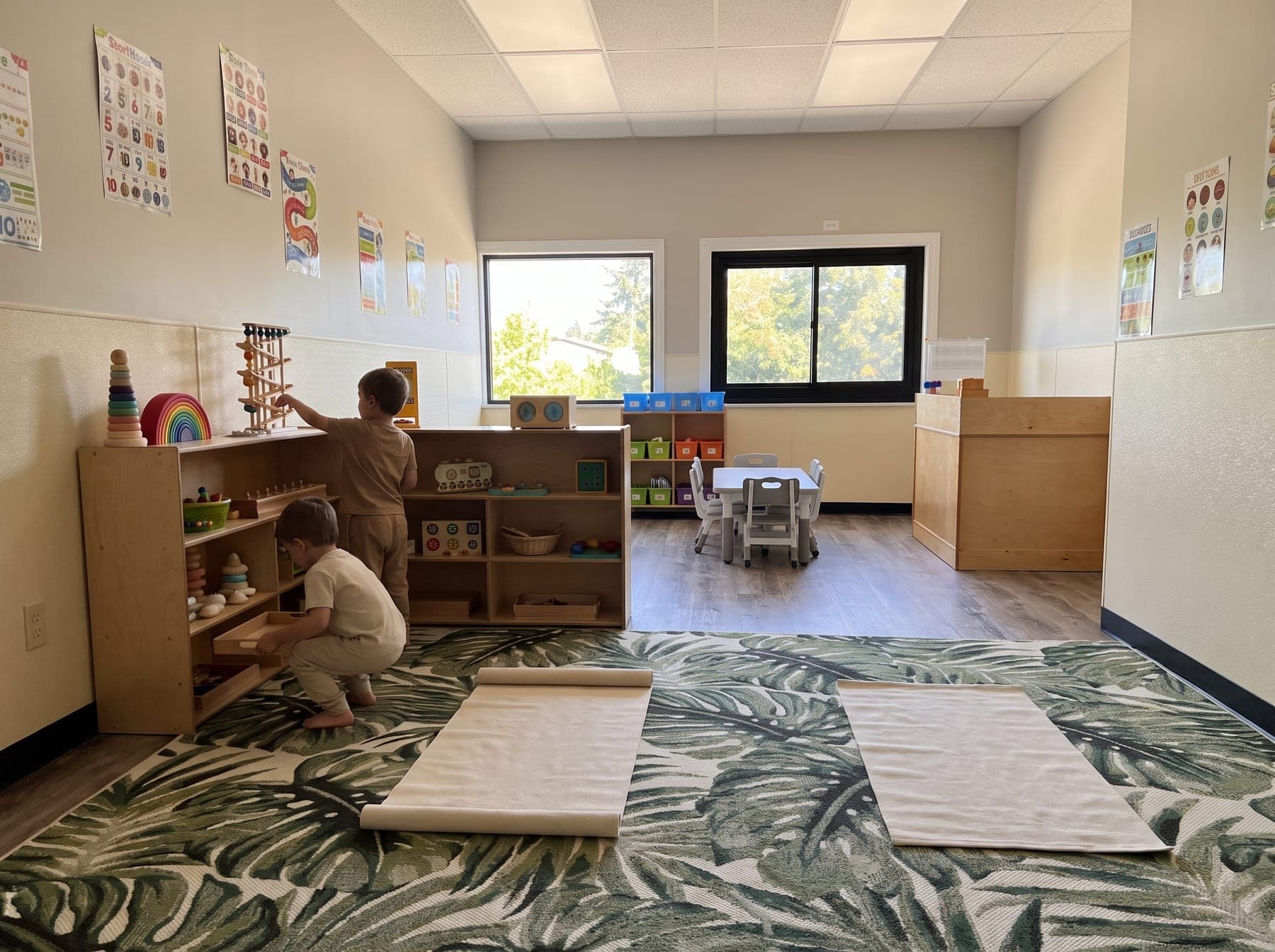 Two children, seen from behind, choosing wooden trays from the low birch shelves during the morning work cycle
